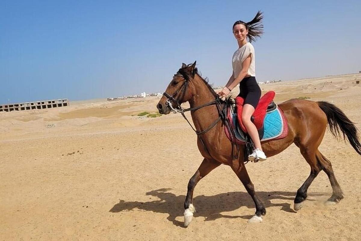 una donna a cavallo sulla spiaggia