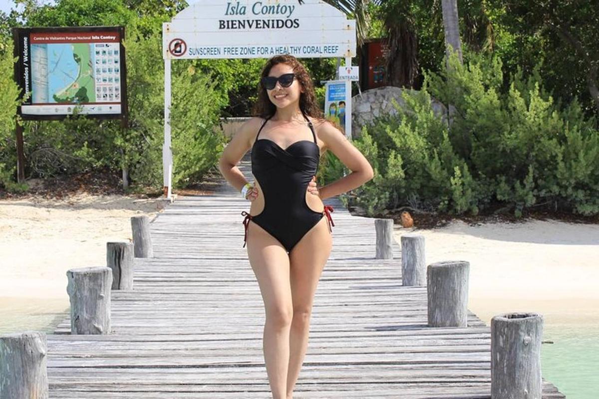 Una mujer en bikini negro parada en un muelle