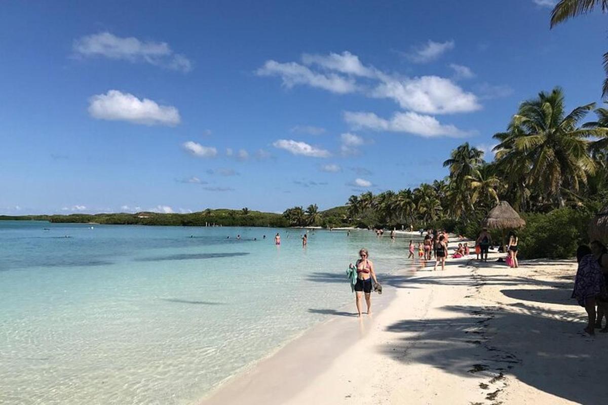 a woman walking on a beach with people in the water