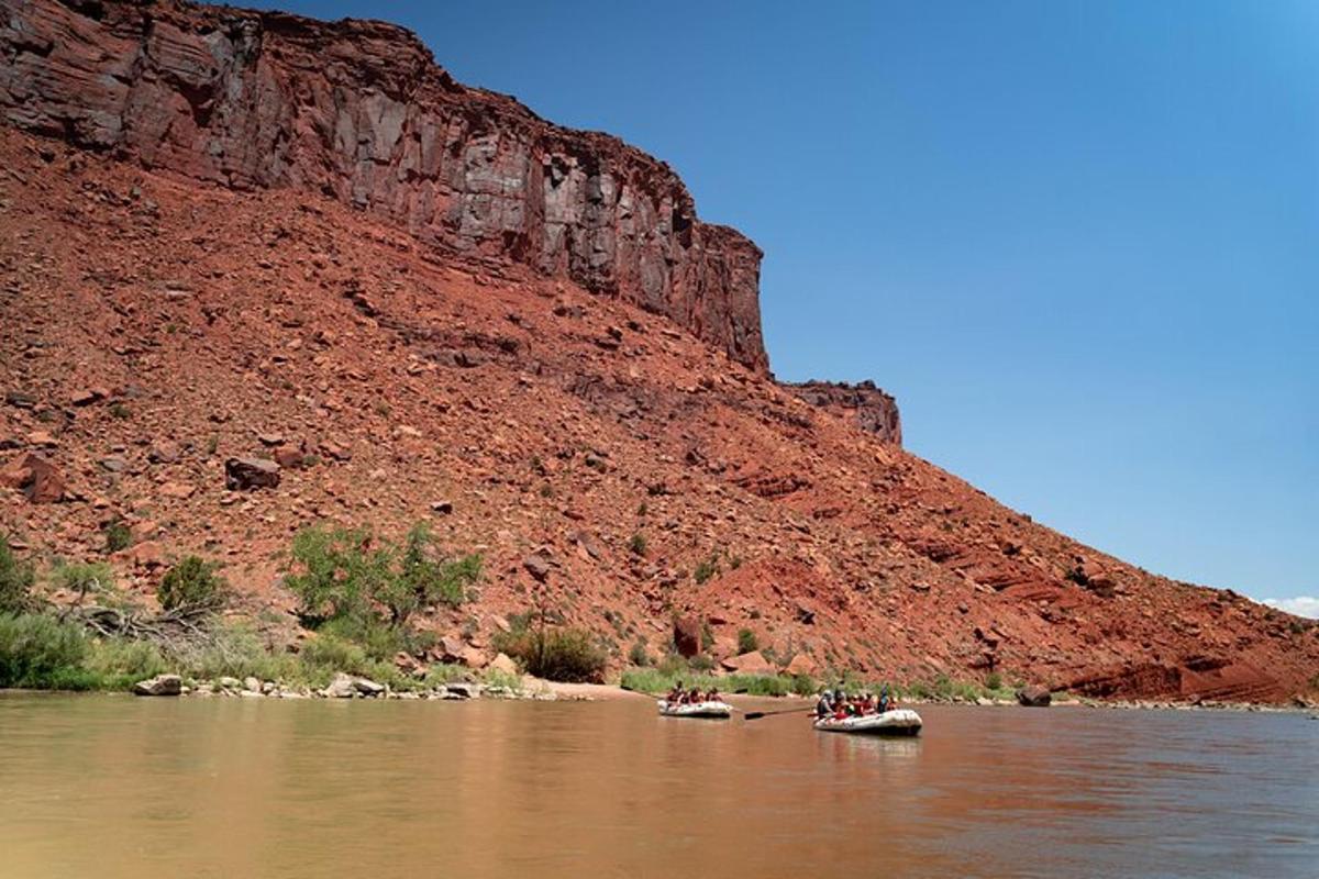 a group of people in canoes on a river next to a mountain