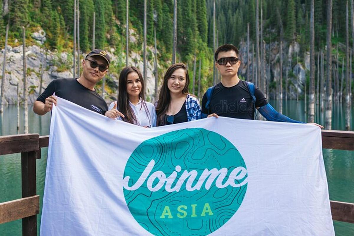 a group of people standing on a fence holding a sign