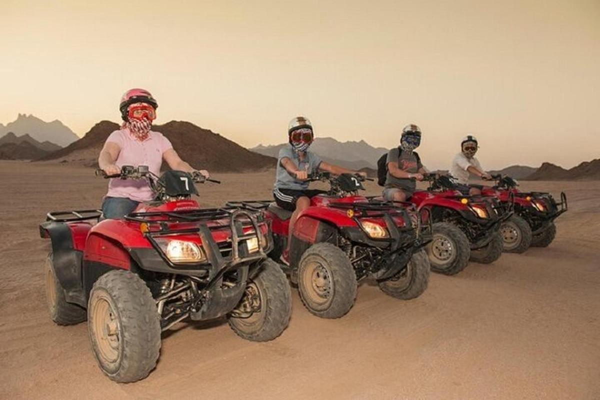 sekumpulan orang menunggang atv di padang pasir