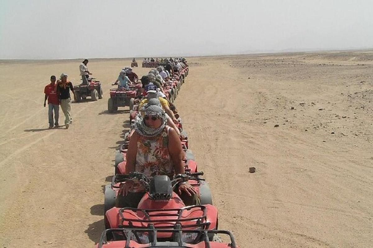 sekumpulan orang menunggang atv di padang pasir