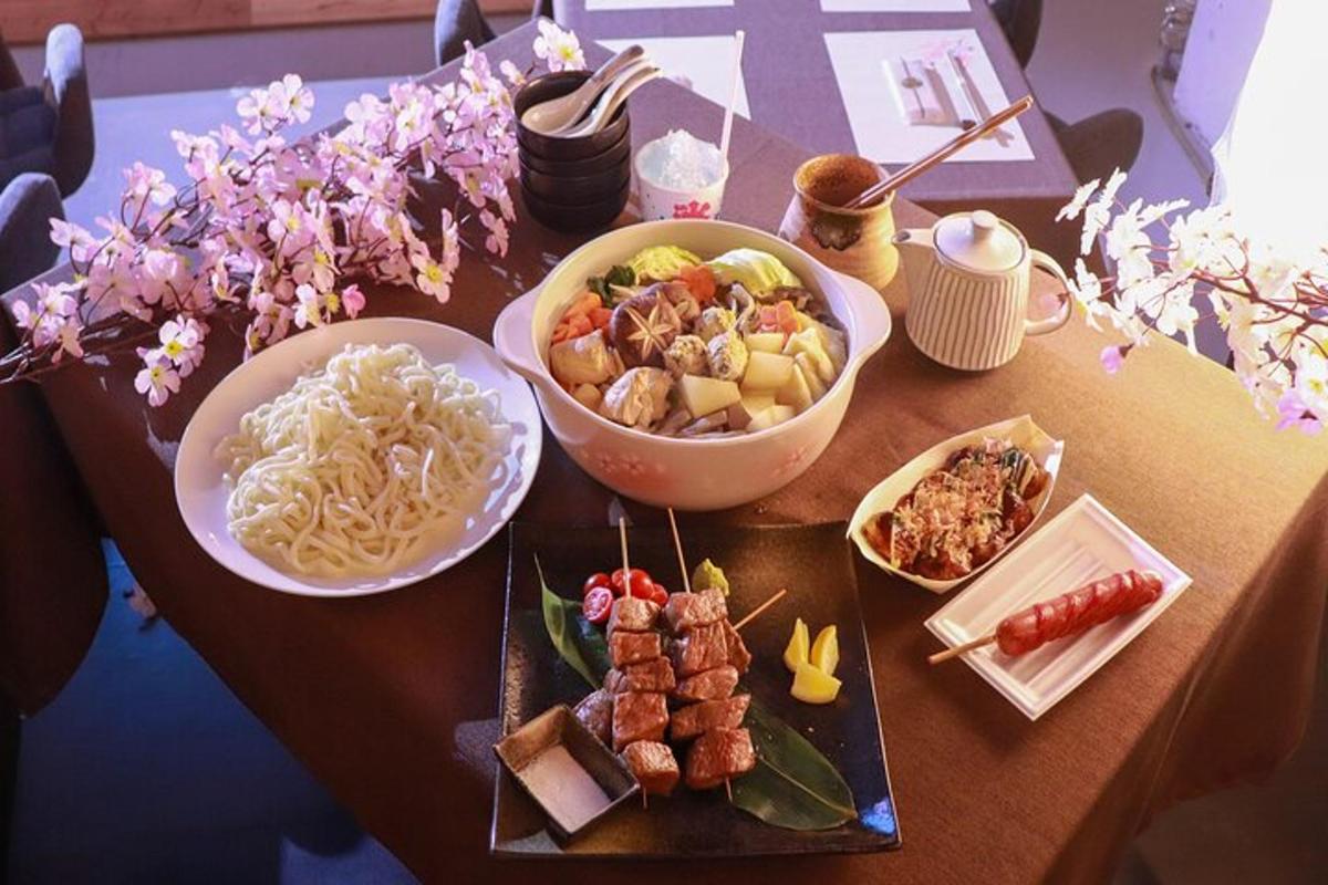 a table with plates of food and a bowl of noodles