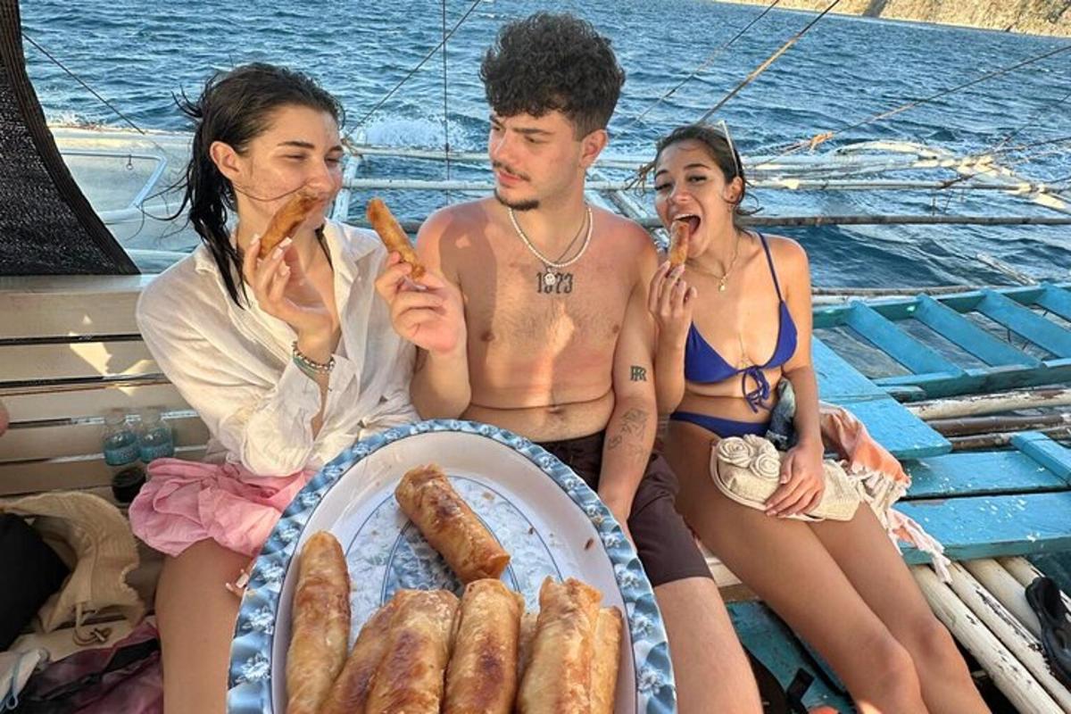 μια ομάδα ανθρώπων που κάθονται σε μια βάρκα τρώνε φαγητό