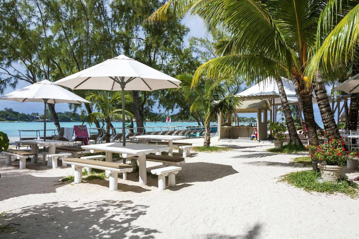 a group of picnic tables and umbrellas on the beach