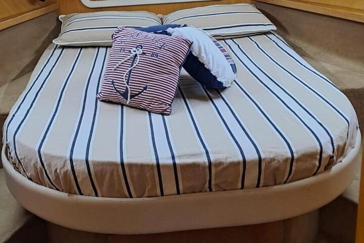 postel s modrými a bílými polštáři