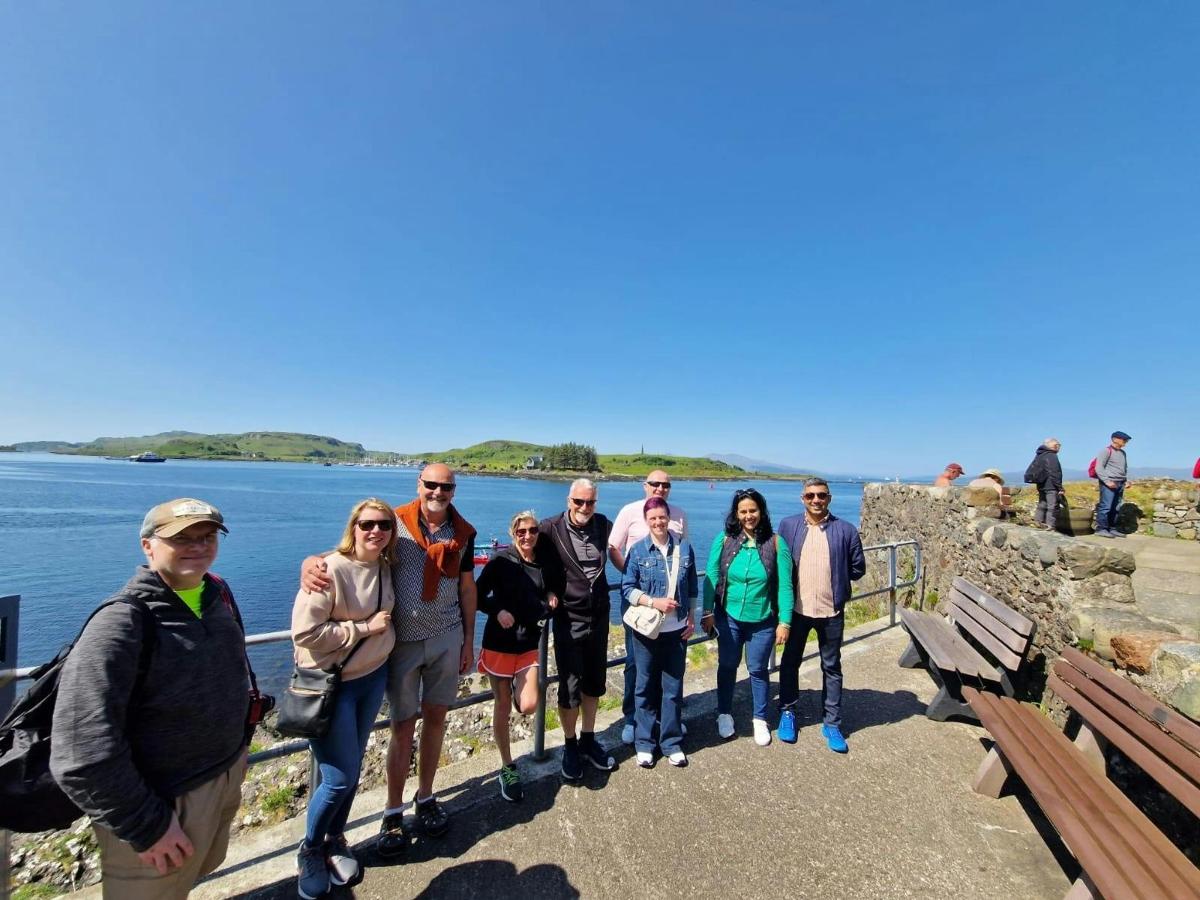 a group of people standing on a wall near the water