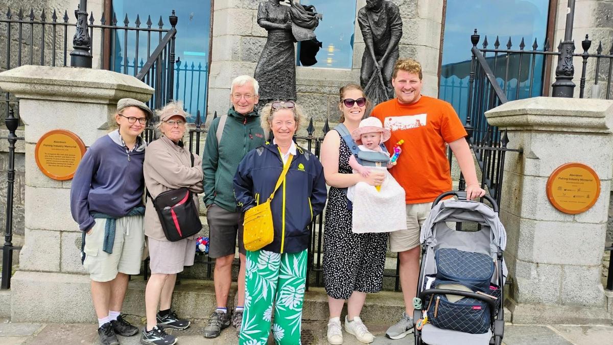 a group of people standing in front of a statue