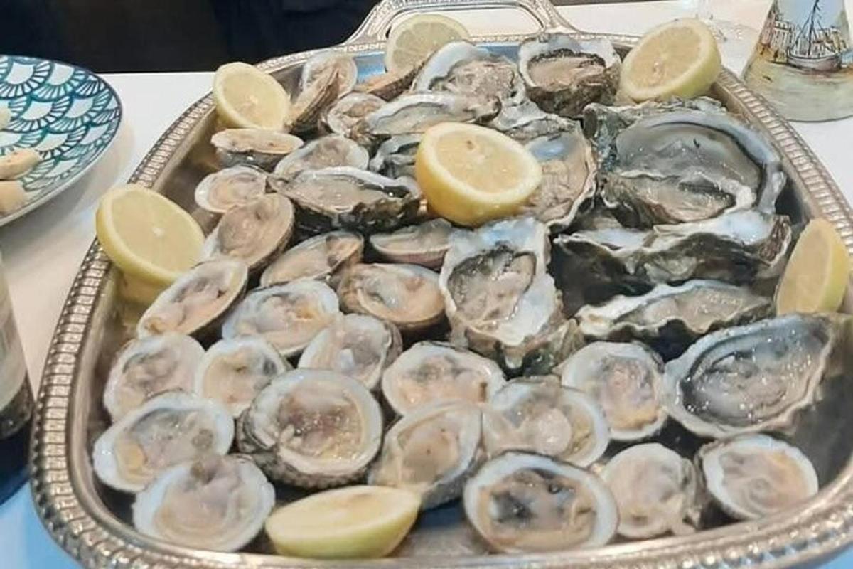 صينية من المحار على طاولة مع شرائح الليمون