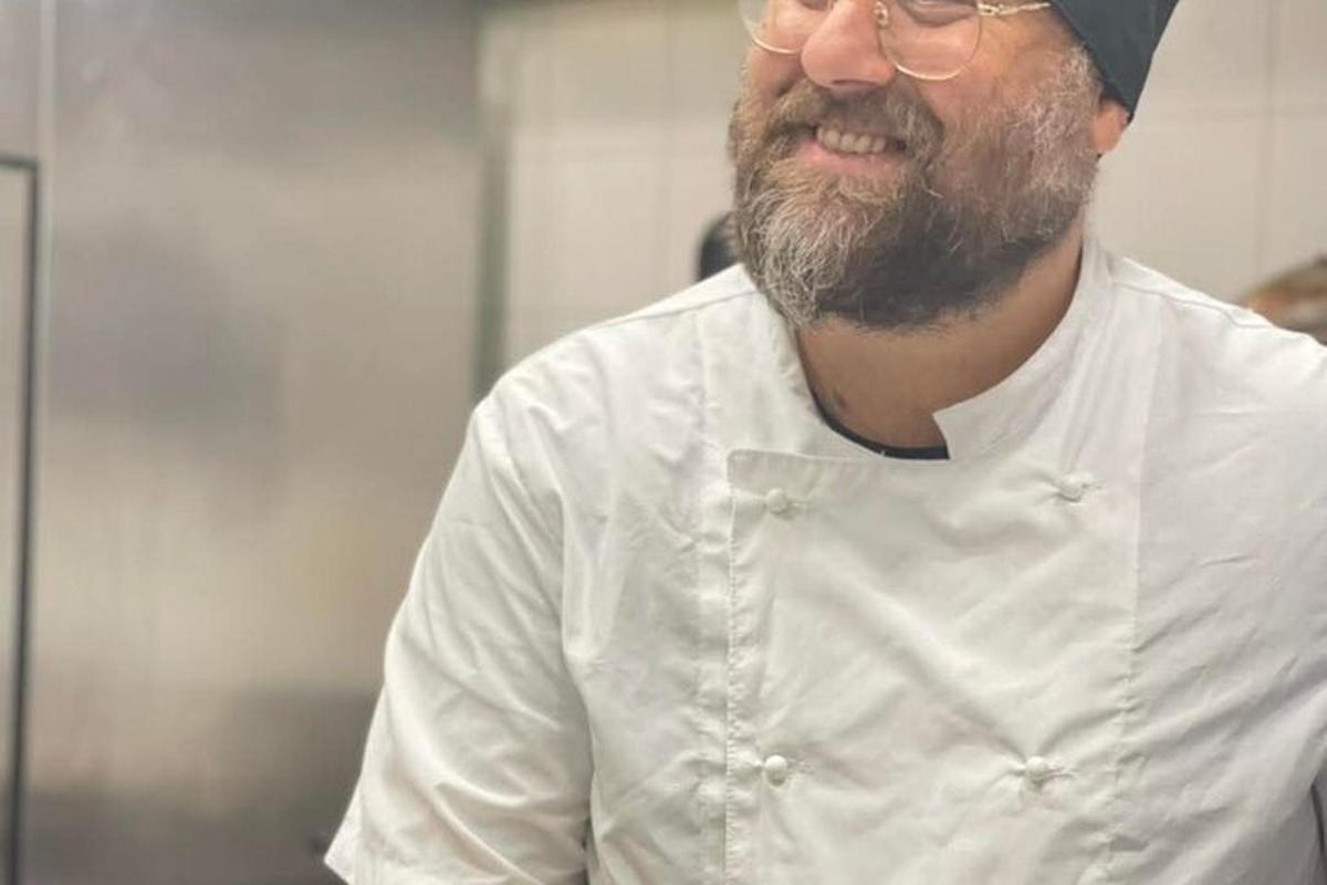 a man with a beard and glasses is smiling