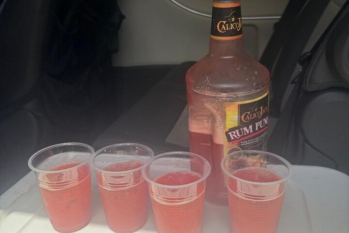 a group of glasses with a bottle of drink