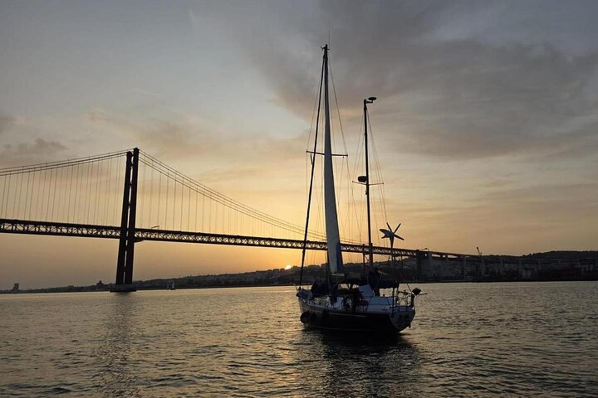 a sailboat in the water in front of a bridge