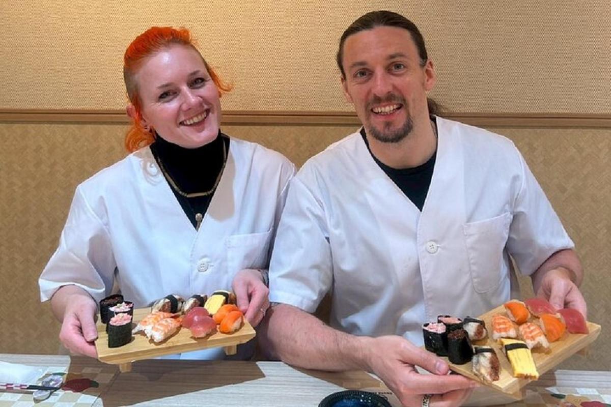 um homem e uma mulher segurando dois pratos de sushi
