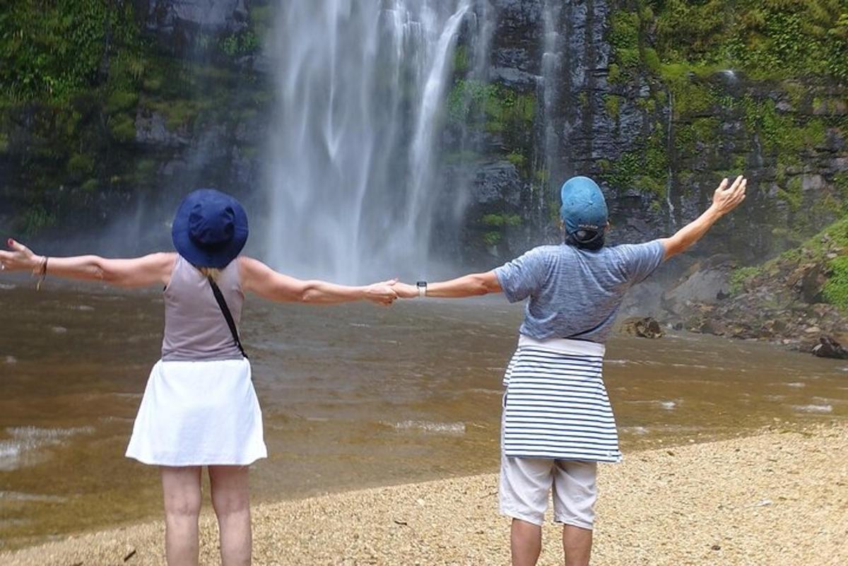 dos personas paradas frente a una cascada
