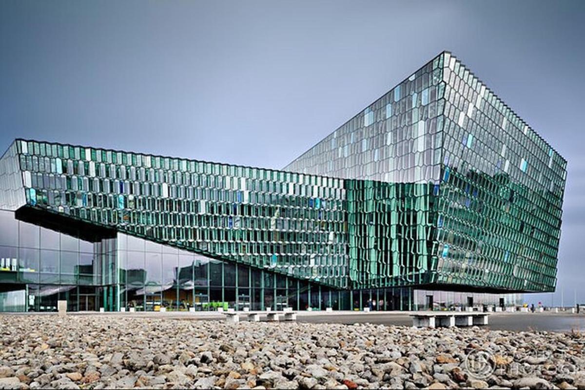 Un gran edificio de cristal con una pila de rocas delante.