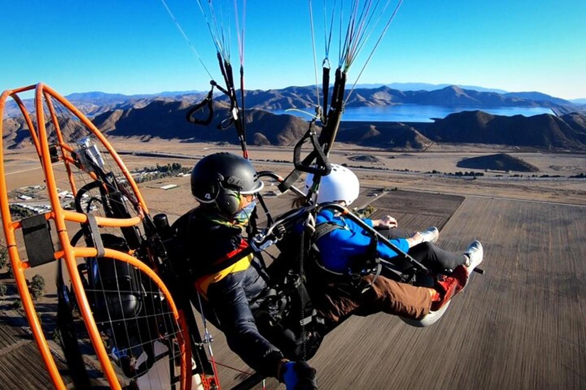 two people are riding a parachute in the sky