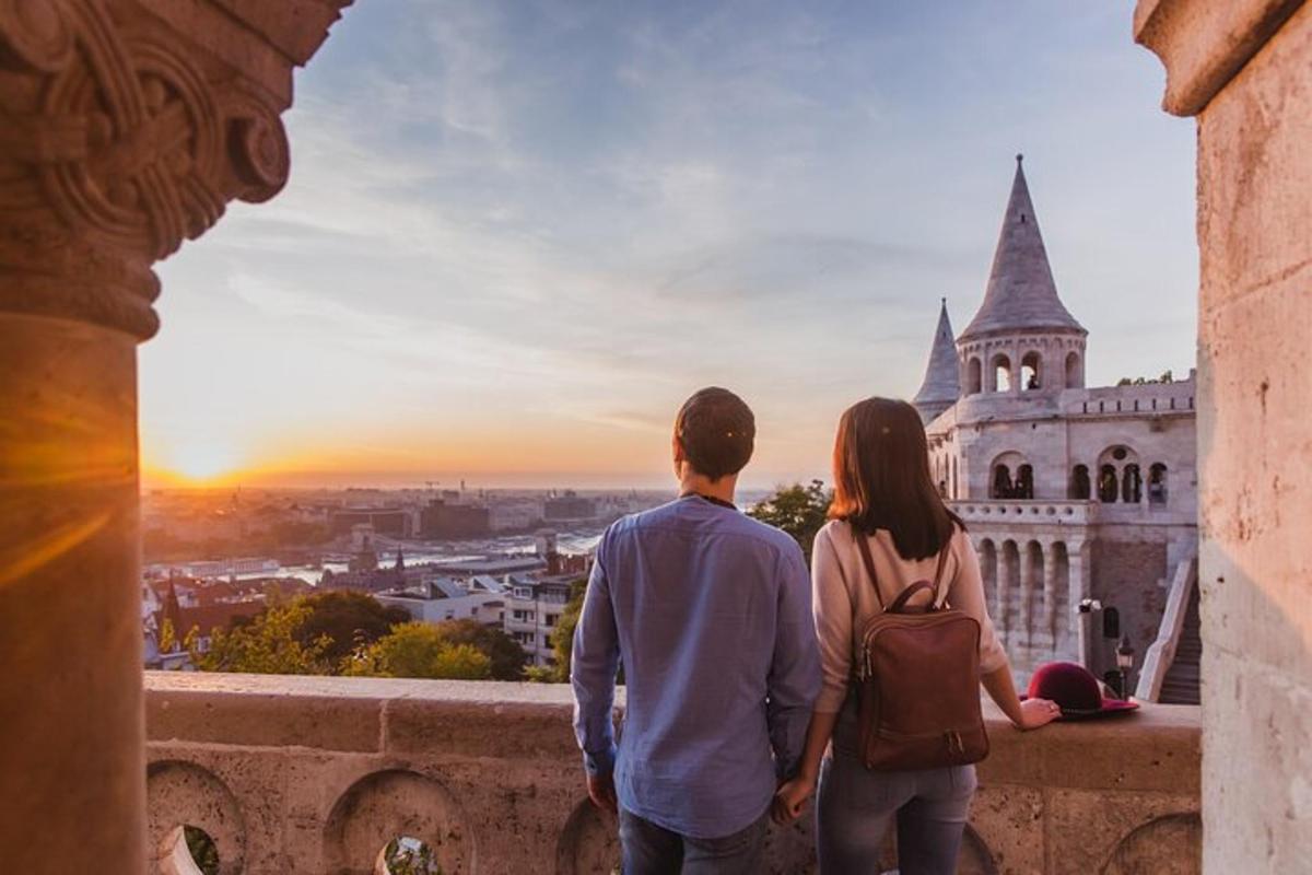Un hombre y una mujer de pie en una cornisa mirando un castillo.