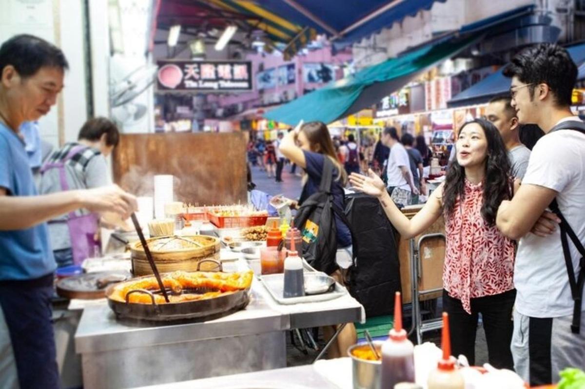 um grupo de pessoas em pé ao redor de um bufê em um mercado