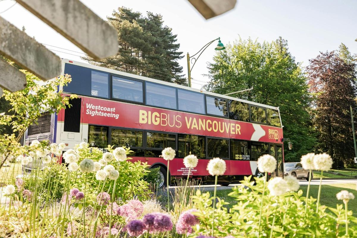 un autobus a due piani parcheggiato in un giardino fiorito