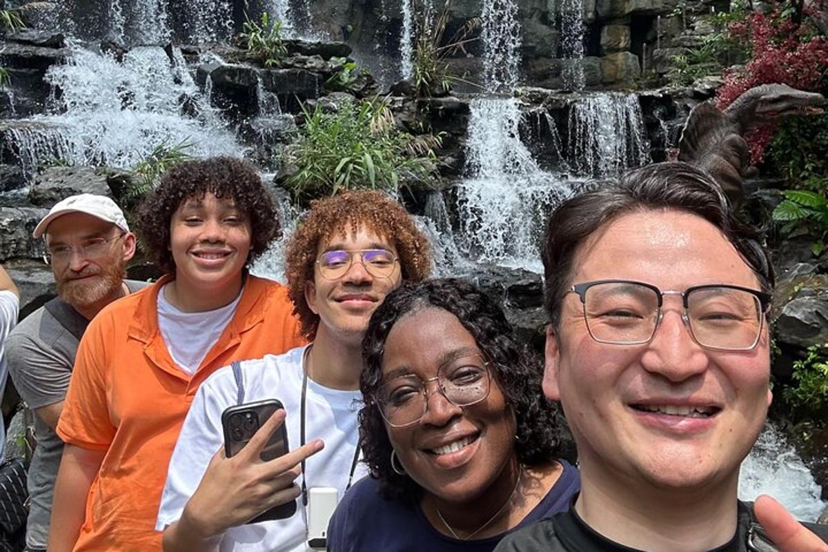 a group of people standing in front of a waterfall