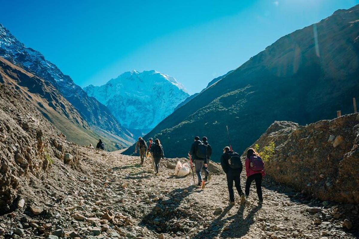 a group of people walking down a mountain trail