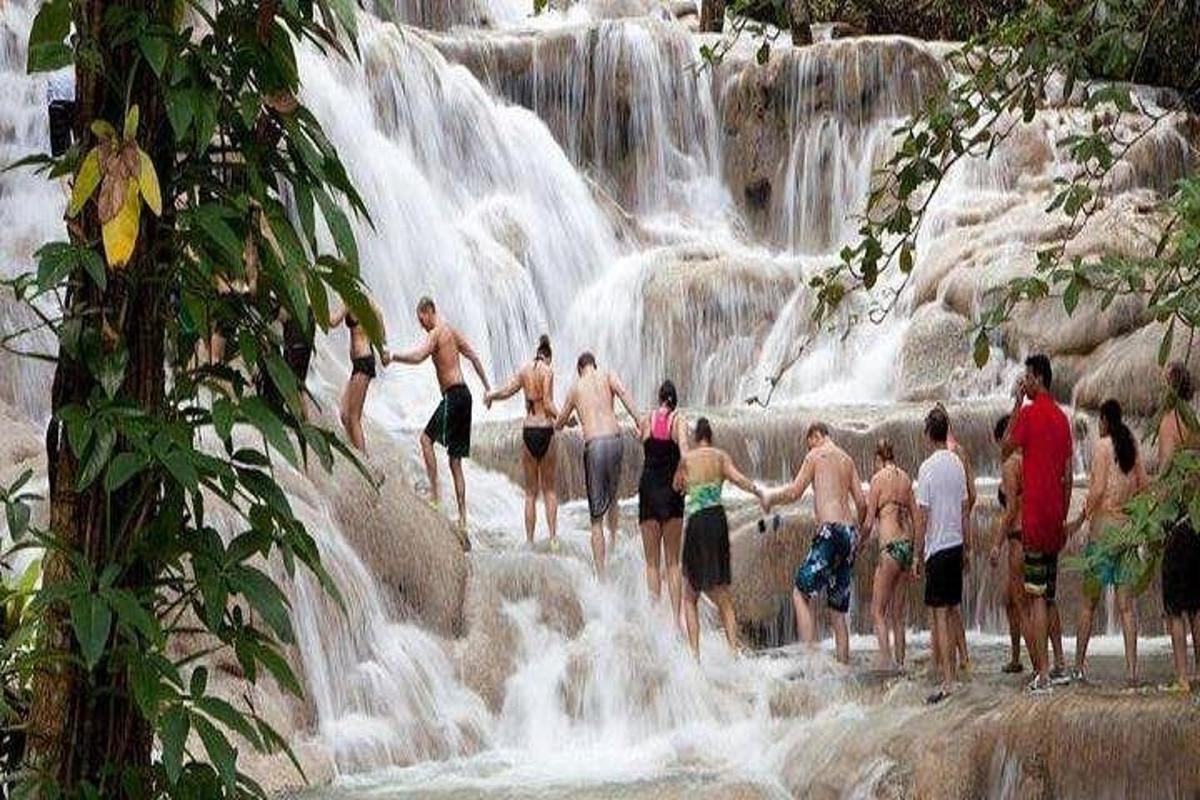 a group of people standing in front of a waterfall