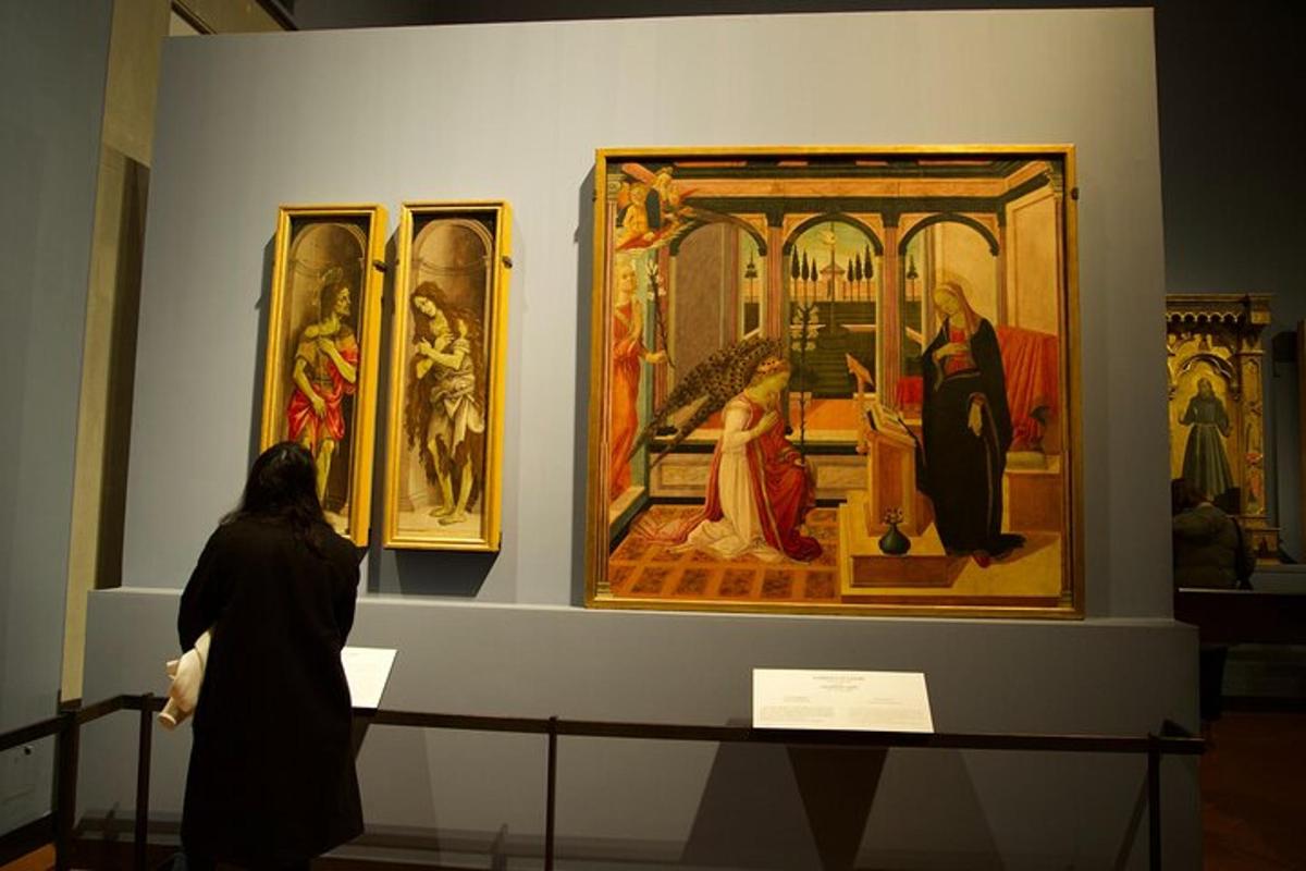 seorang wanita melihat lukisan yang dipamerkan di muzium