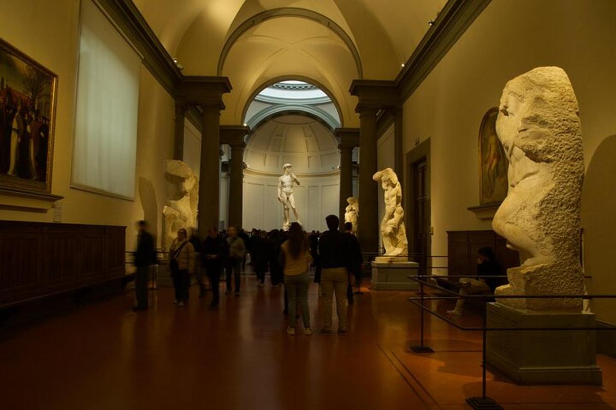 en gruppe mennesker går gennem et museum med statuer