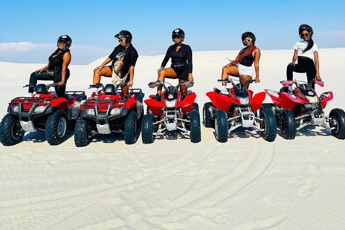 a group of people sitting on atvs in the sand