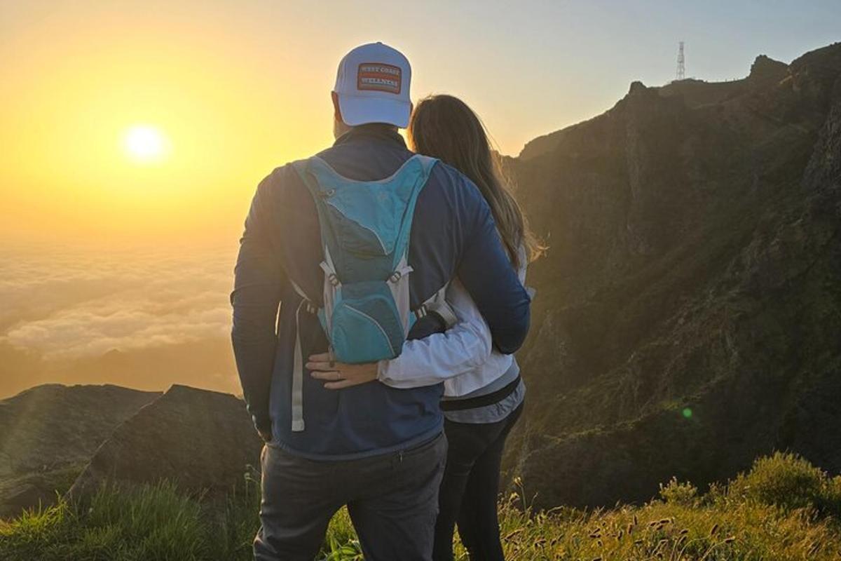 um homem e uma mulher em pé no topo de uma montanha