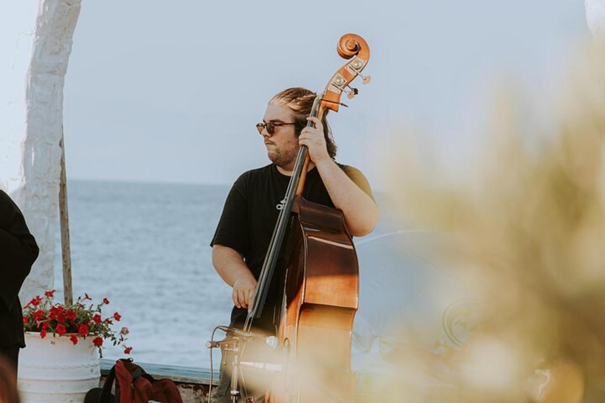một người đàn ông đang chơi đàn cello bên bờ biển
