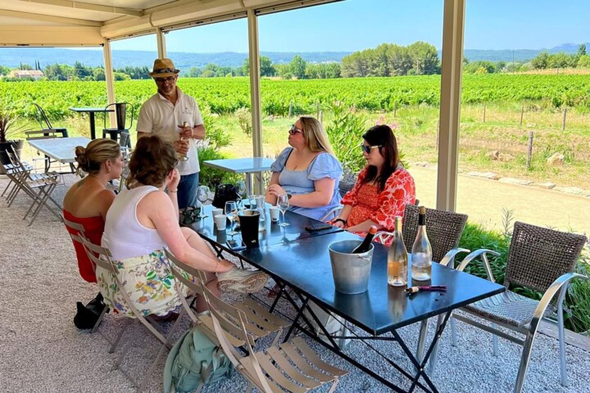 un grup de oameni așezați la o masă cu pahare de vin
