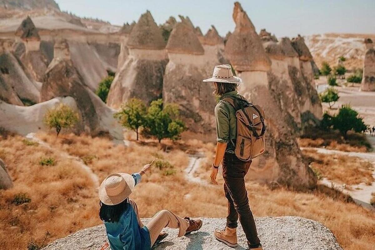 hai người đứng trên một tảng đá nhìn xuống hẻm núi