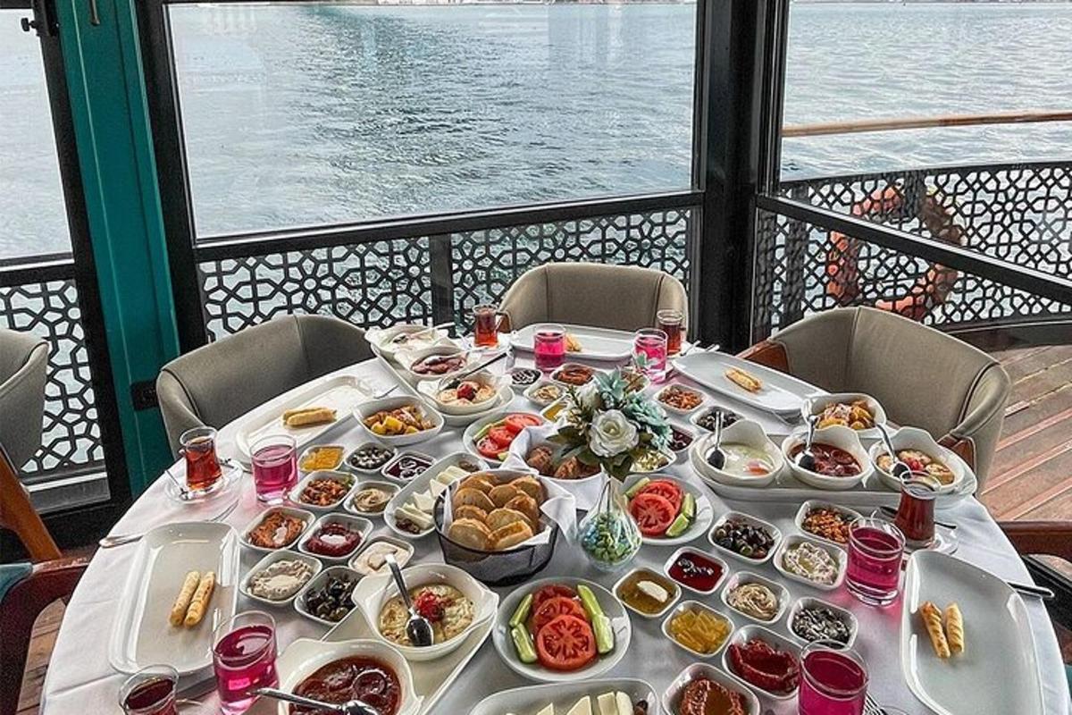 Una mesa con comida con vista al agua.
