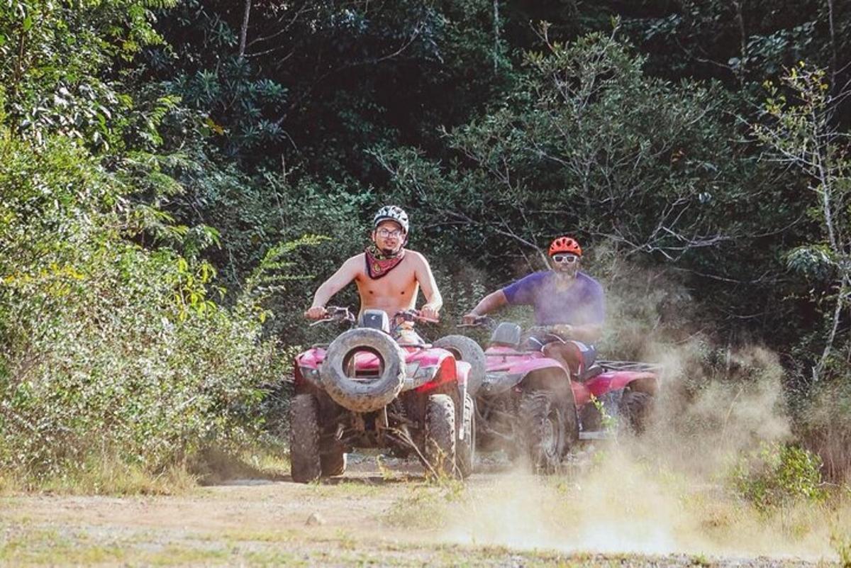 未舗装道路でATVに乗っている2人の男性