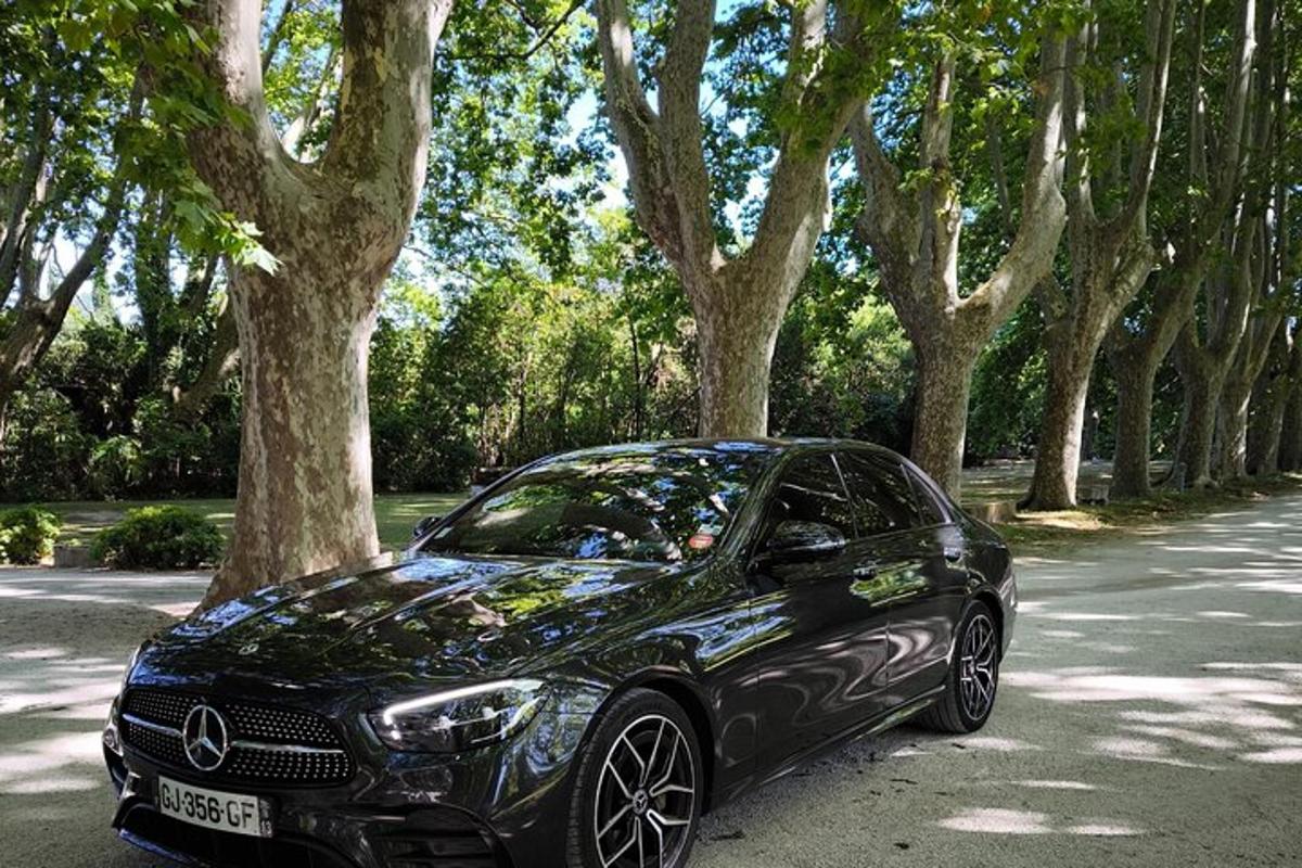 a black car parked on a road with trees