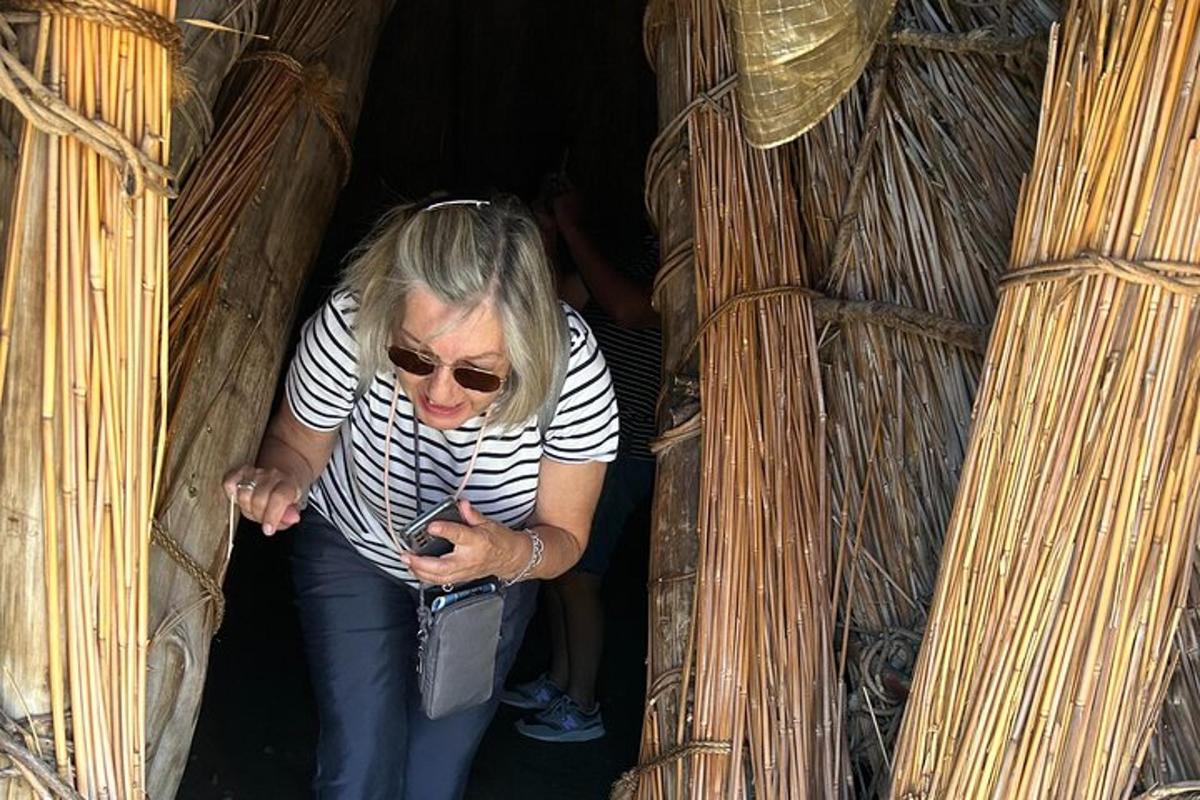 žena se dívá na svůj mobilní telefon v bambusové budově