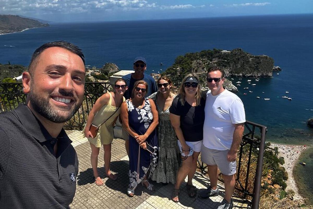un gruppo di persone in posa per una foto di fronte all'oceano