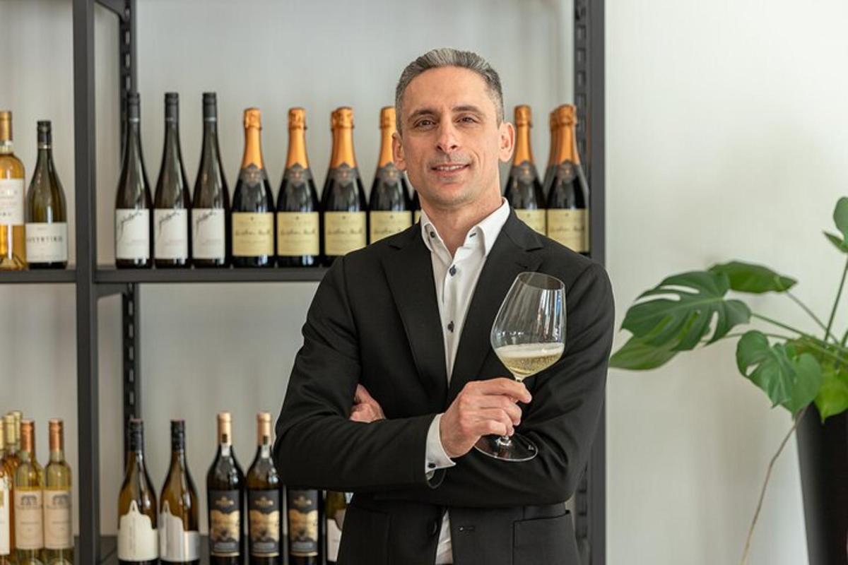 un uomo in giacca e cravatta che tiene in mano un bicchiere di vino
