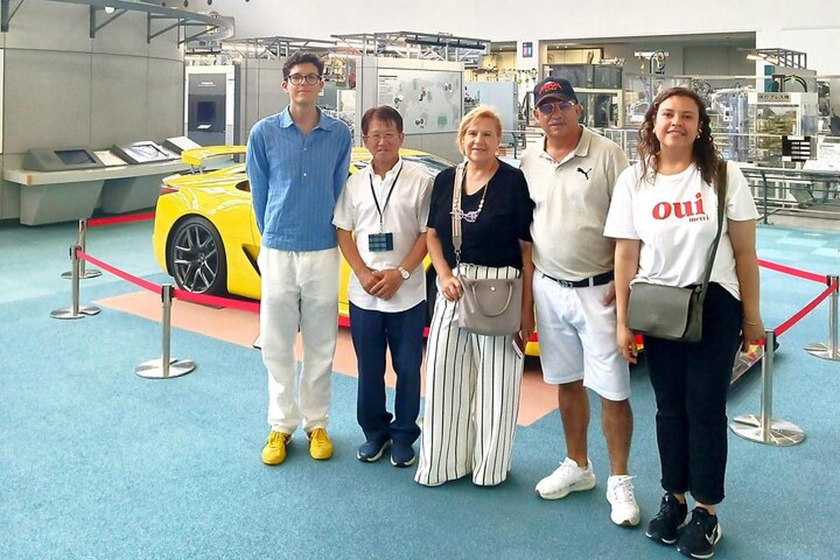 a group of people standing in front of a yellow car