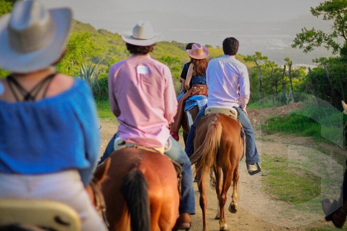 a group of people riding horses down a dirt road
