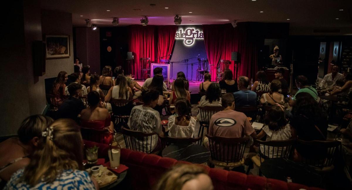 a crowd of people sitting in a room with a stage