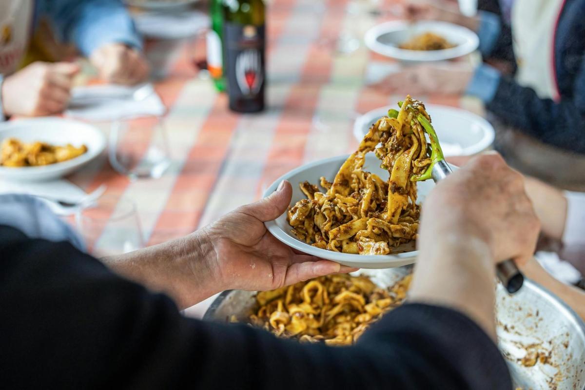 seseorang memegang semangkuk makanan di atas meja
