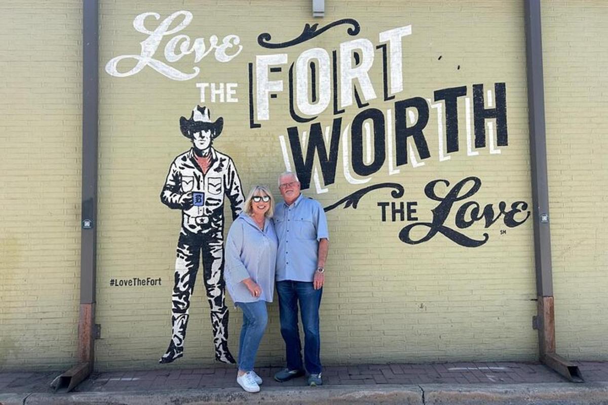 a man and a woman standing in front of a mural