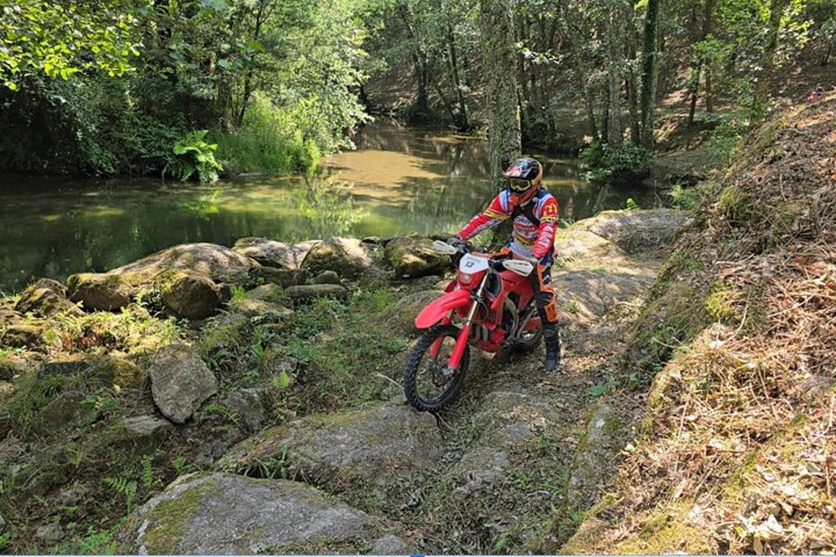 a person riding a dirt bike on a river