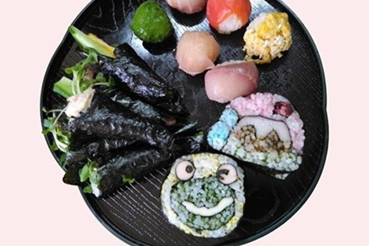 černý talíř jídla se sushi na něm