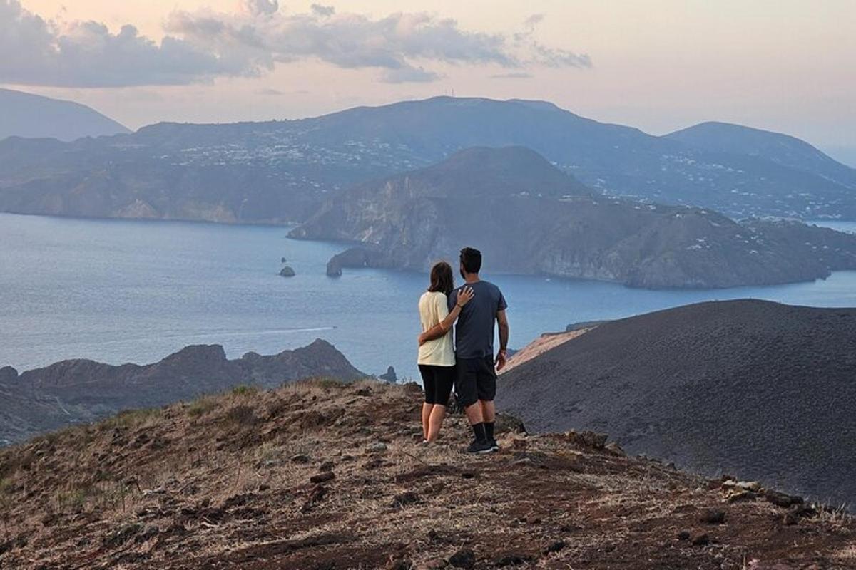 a man and woman standing on top of a mountain
