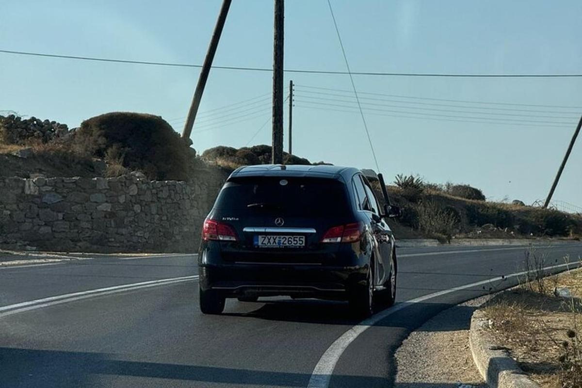 um carro preto dirigindo por uma estrada