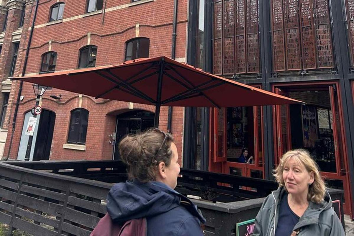 to kvinner står under en rød paraply